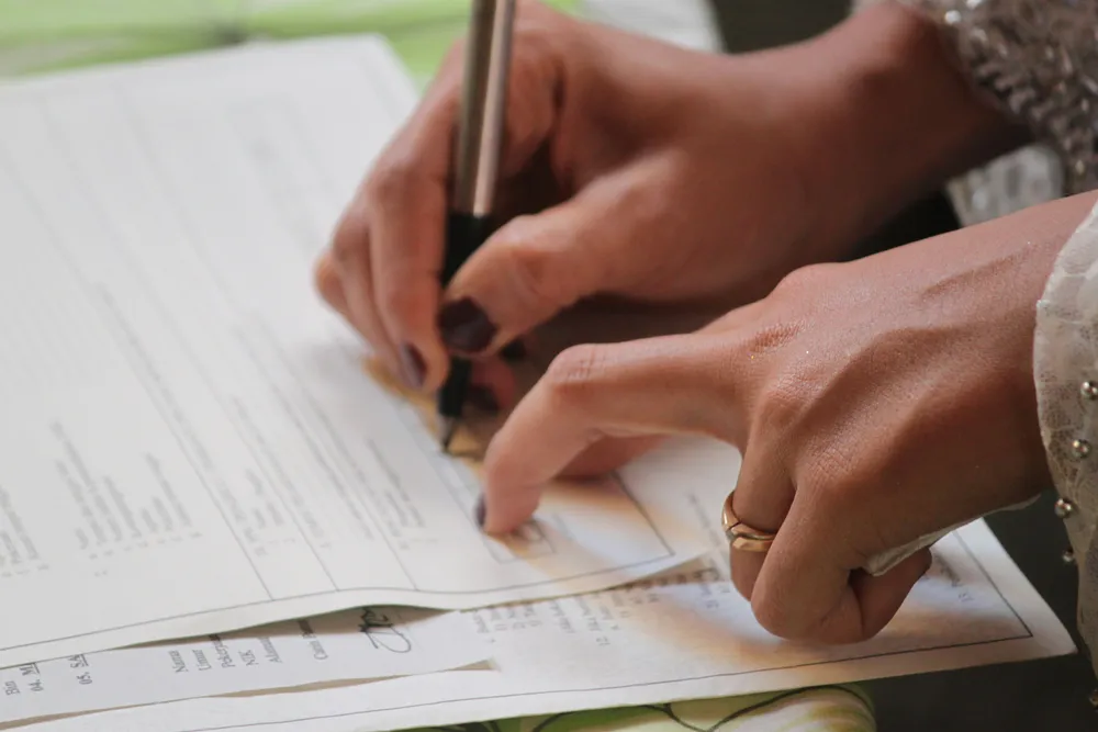 Firma de un documento sobre la mesa, representando los contratos y el cumplimiento normativo